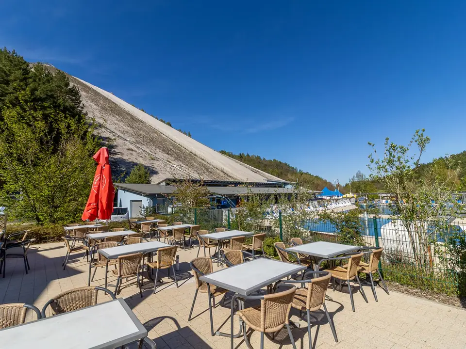 Terrasse mit roten Sonnenschirmen vor dem Monte Kaolino
